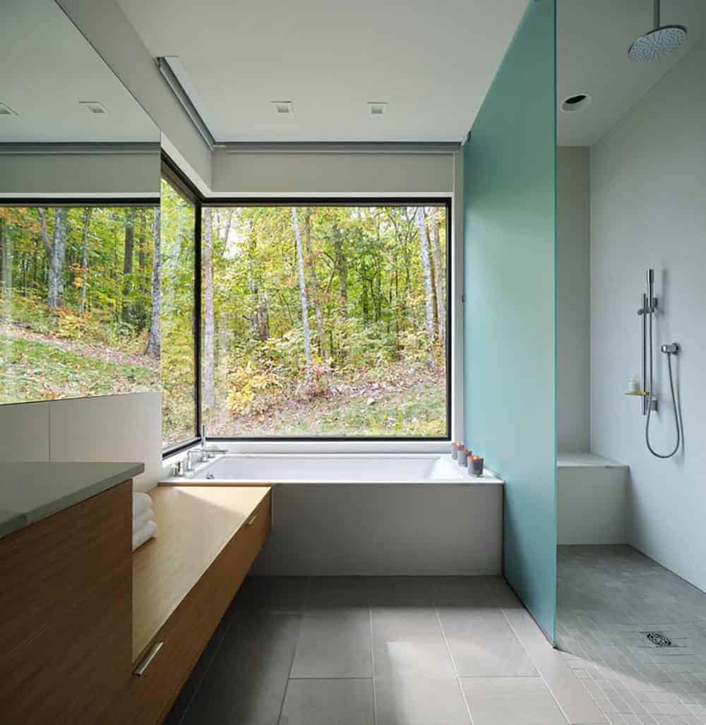 modern bathoom with a forest view through a large window