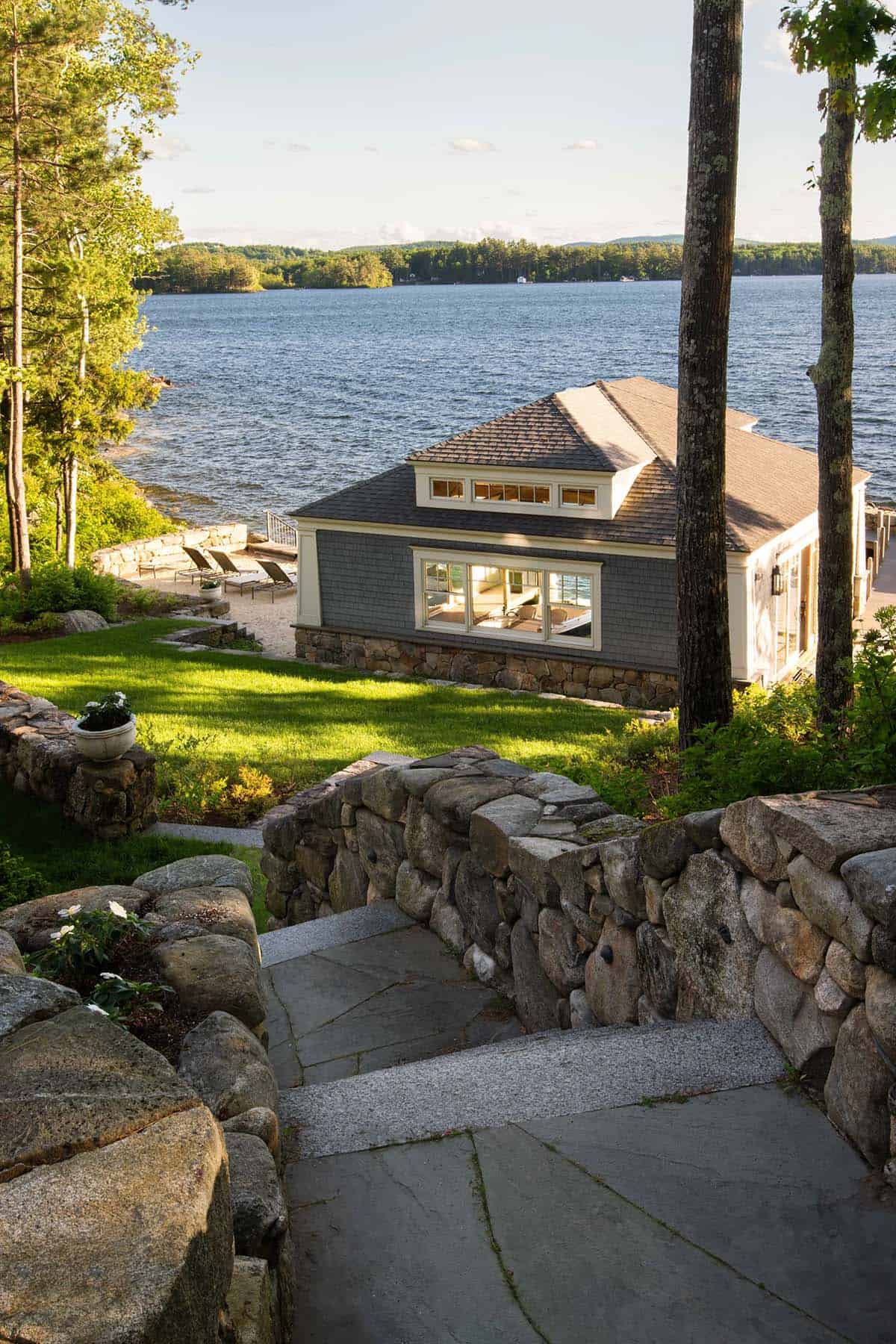 shingle style lake house exterior with a walkway leading to the boat house