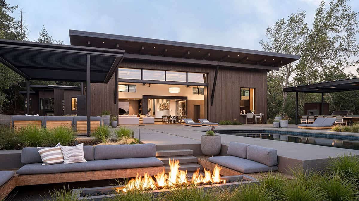 modern home exterior with a firepit at dusk