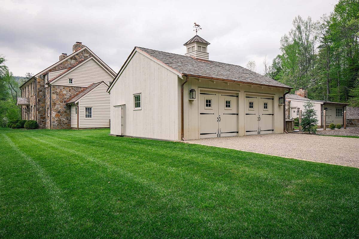 stone farmhouse exterior with a carriage barn-style garage
