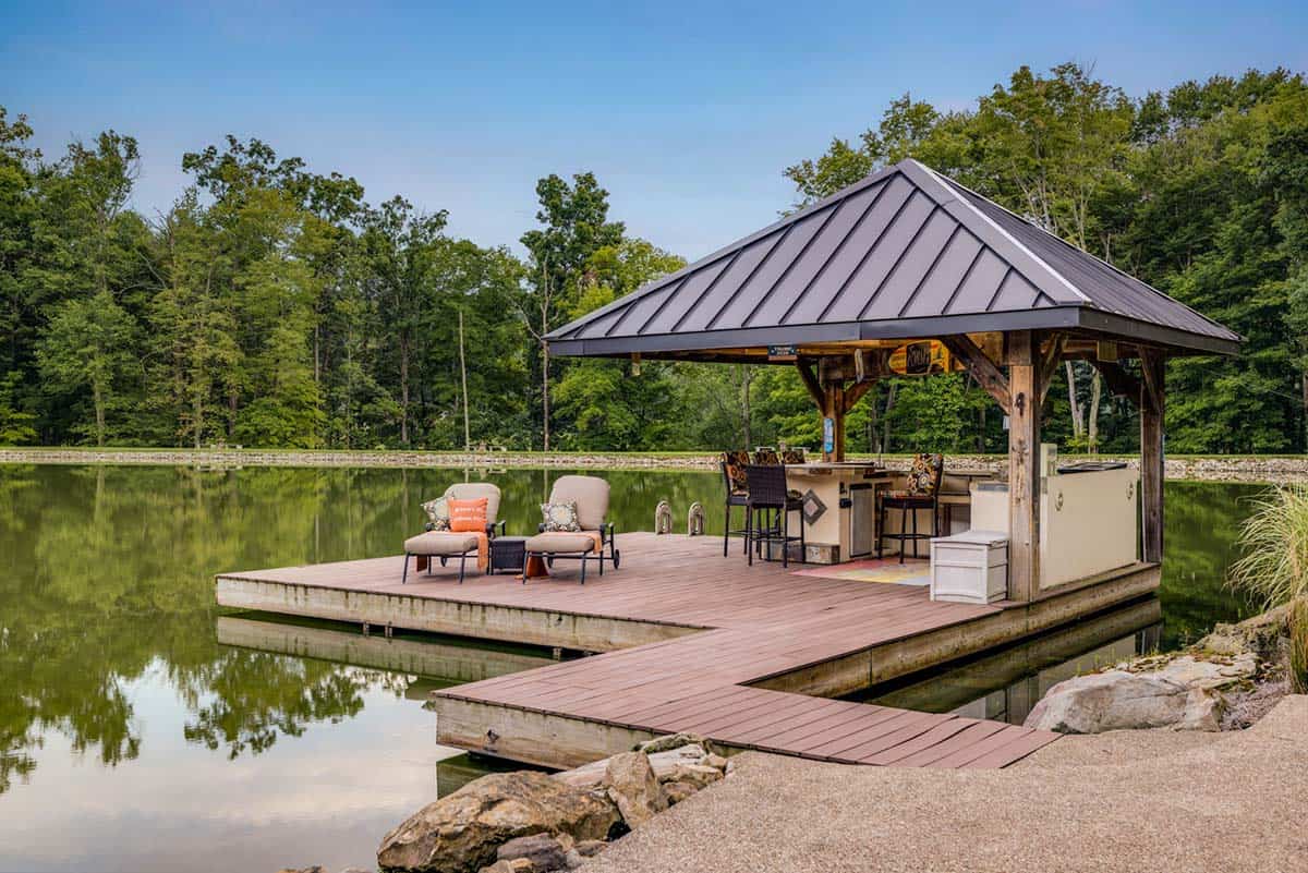 timber frame house exterior with a pond and boat dock