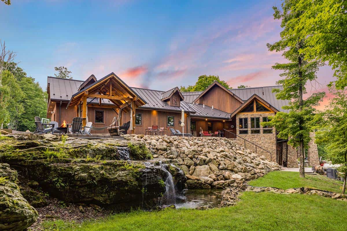 timber frame house exterior backyard view with a waterfall