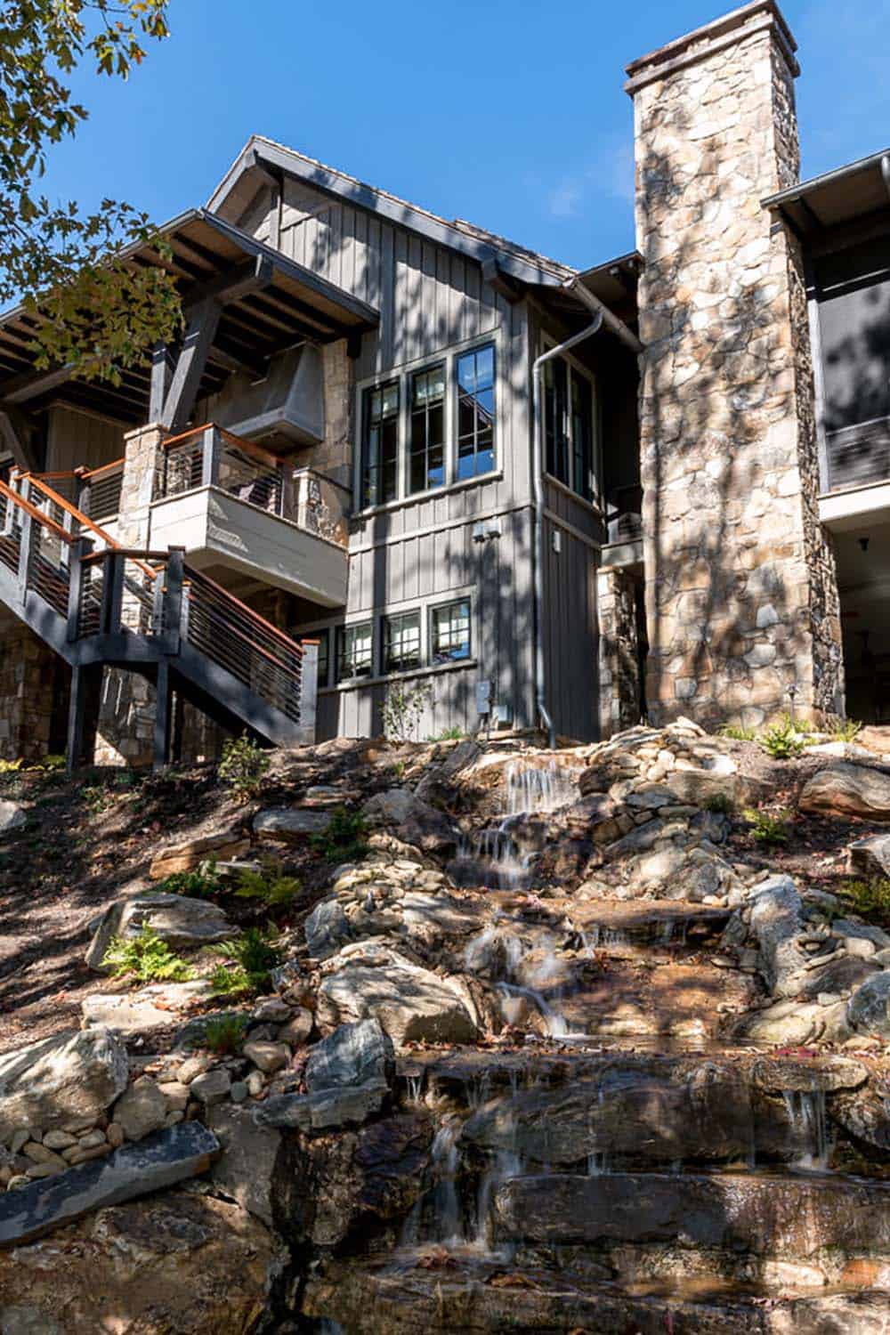 modern rustic lake house exterior with a waterfall