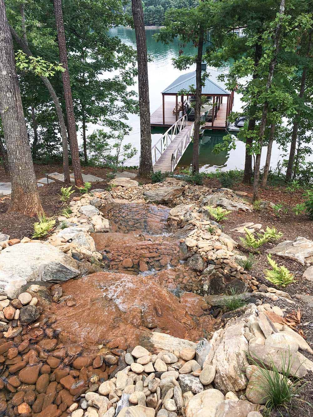 modern rustic lake house exterior with a waterfall