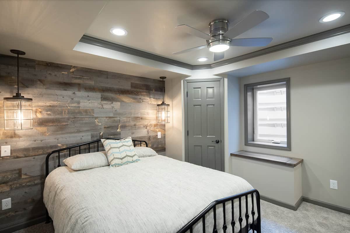Transitional style basement guest bedroom with a wood accent wall