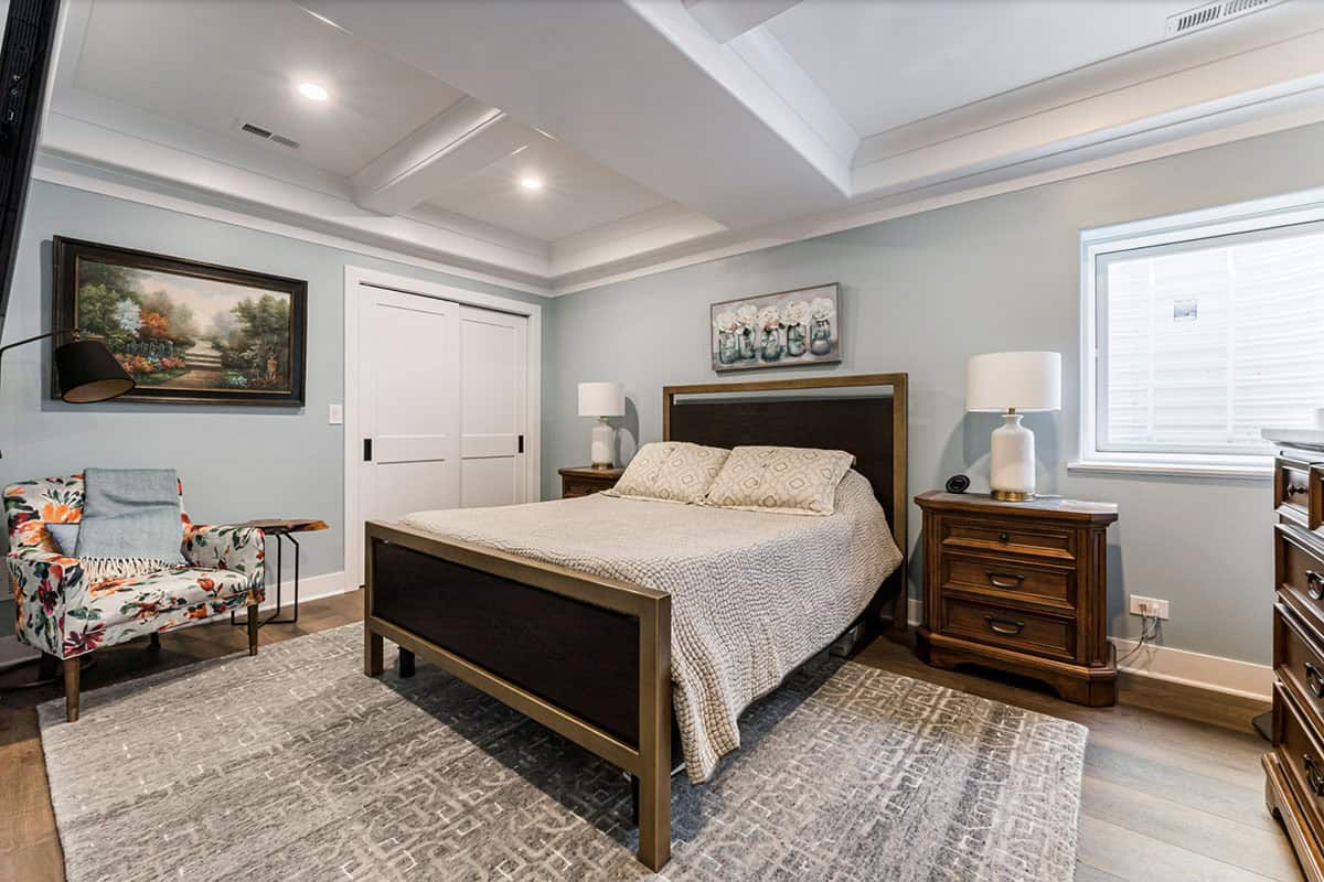 transitional style guest basement bedroom with coffered ceilings