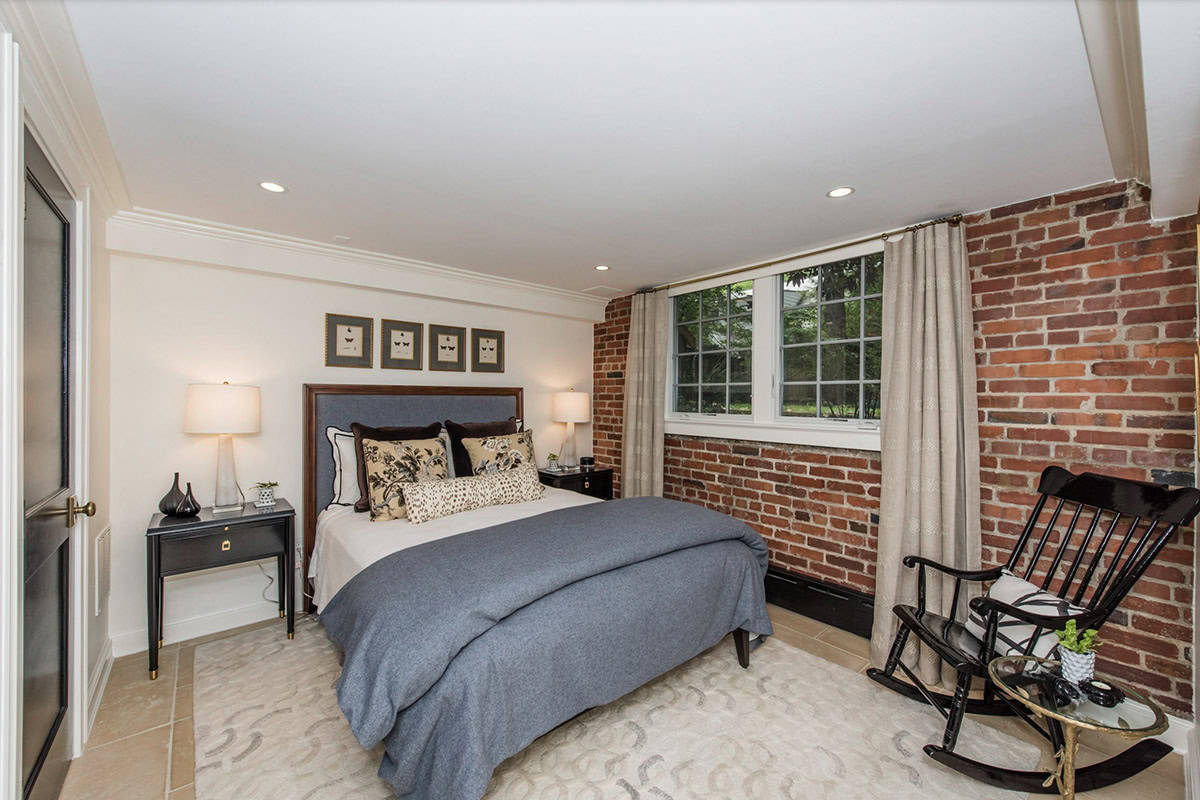 Rustic Transitional Basement Guest Bedroom with an exposed brick wall