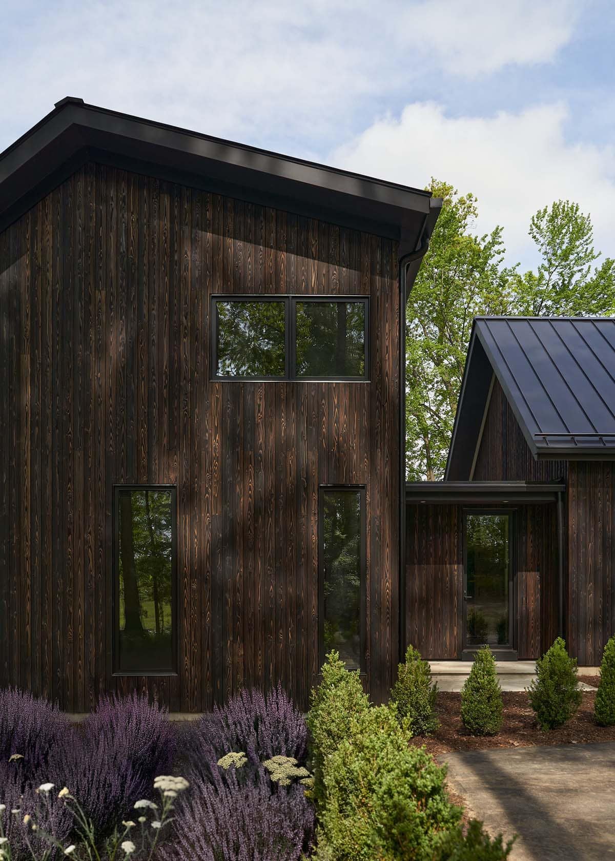 lake house exterior with dark shou sugi ban siding