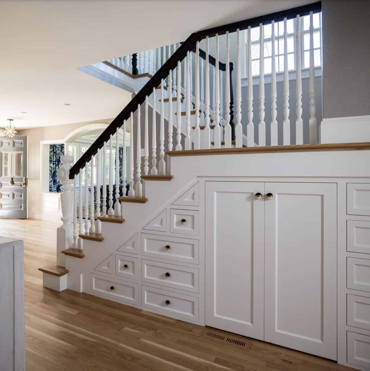 traditional style staircase with built-in drawers and a secret door