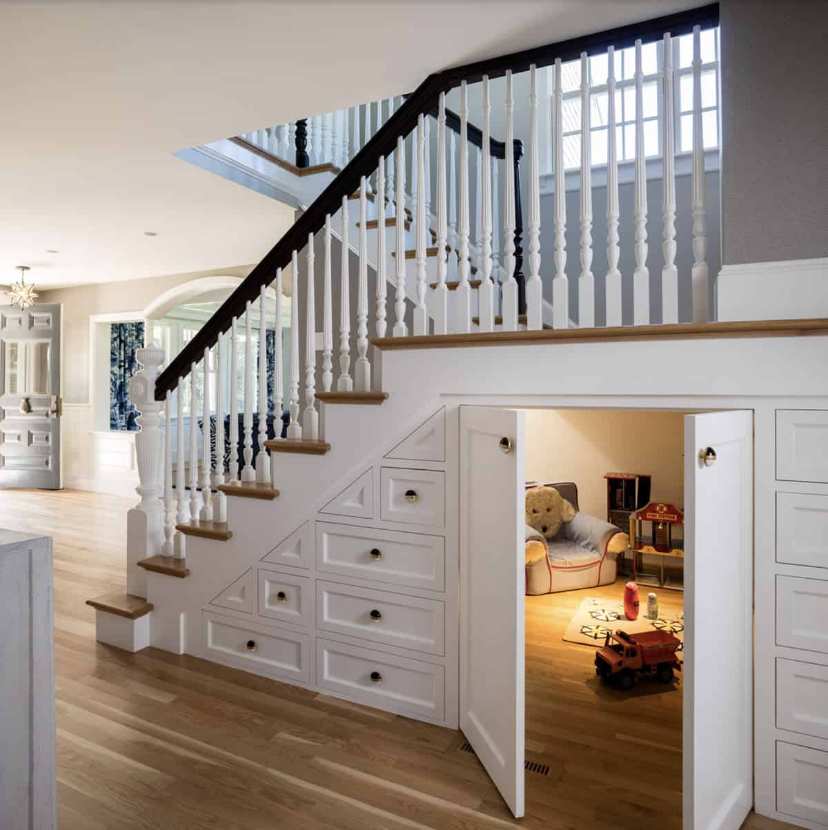 traditional style staircase with a secret door leading into a playroom