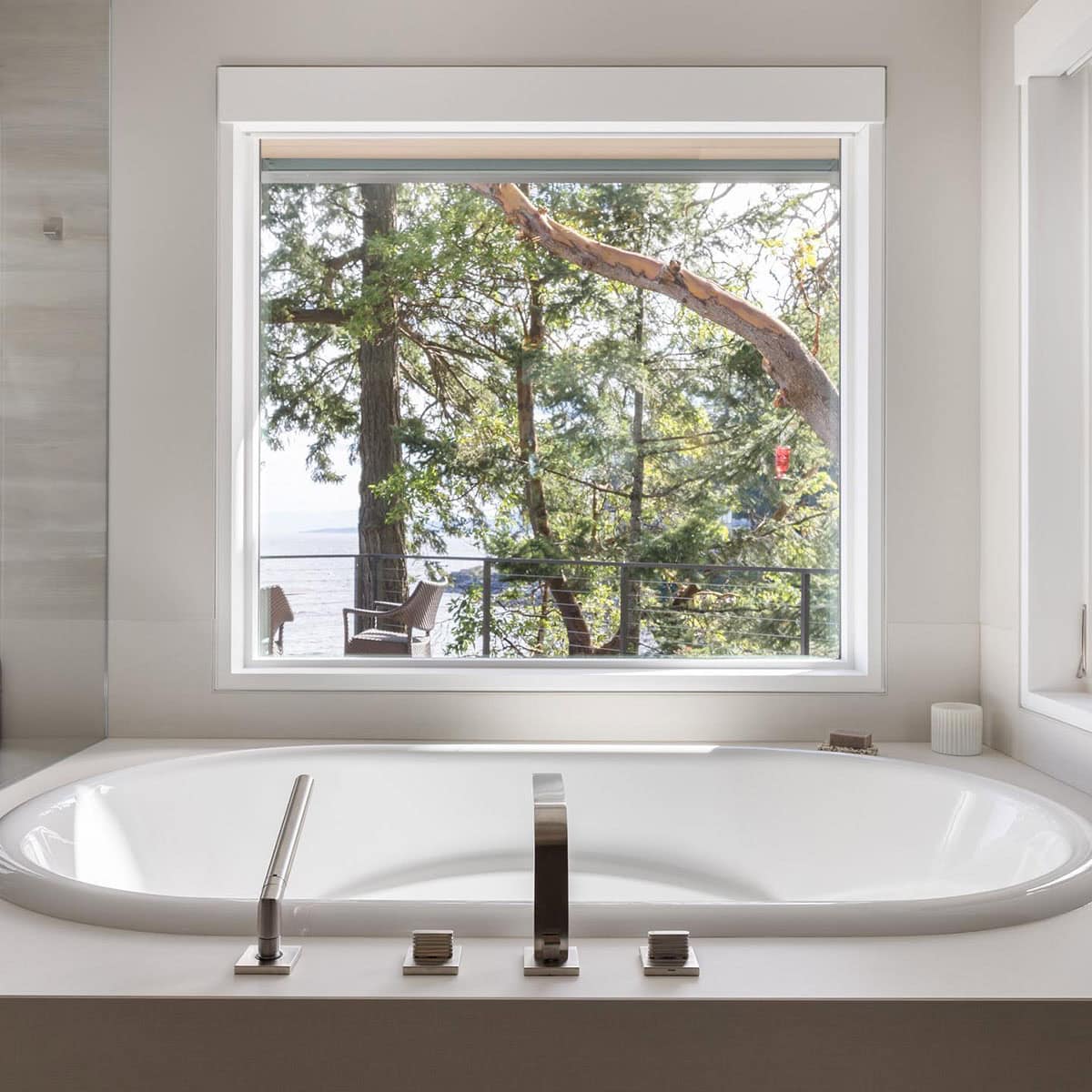 coastal modern bathroom with an integrated tub and picture window