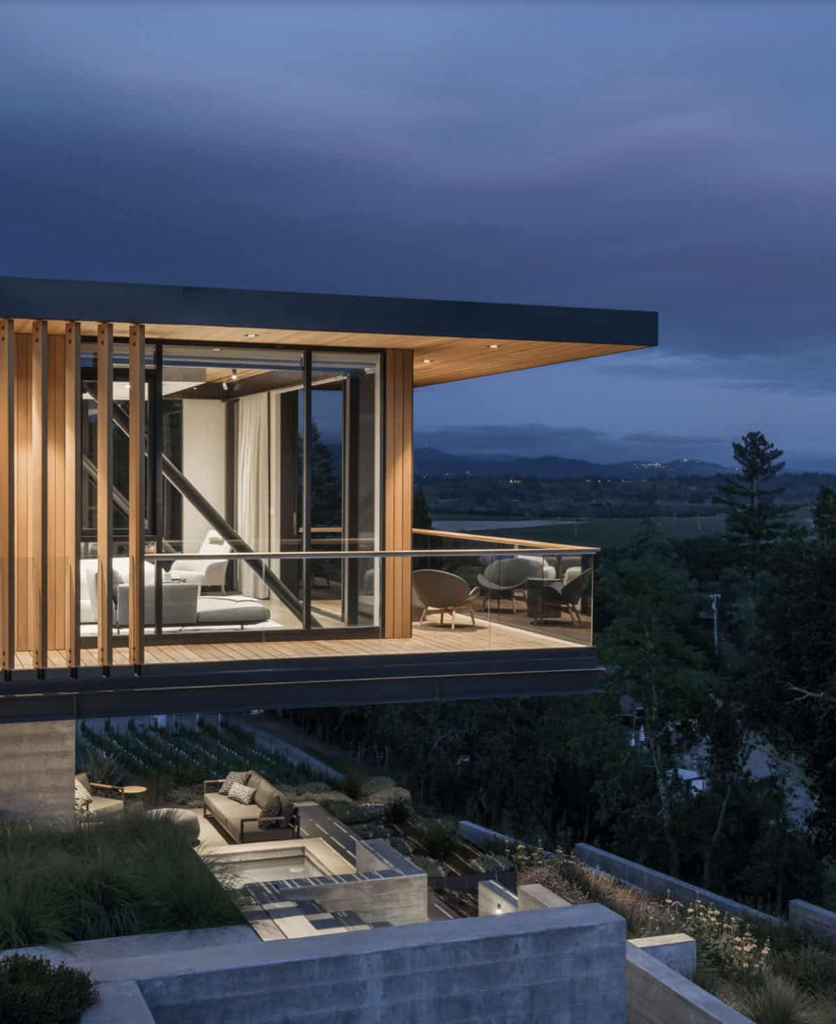 contemporary home exterior cantilevered over a hillside at dusk