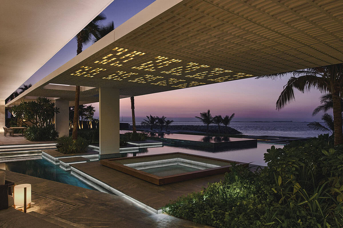 A serene pool area at a beachfront villa, surrounded by palm trees and sun loungers, with ocean views