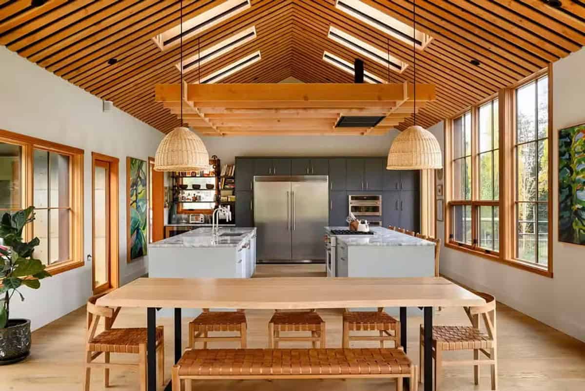 Modern farmhouse kitchen with wooden ceiling and large windows on Orcas Island.