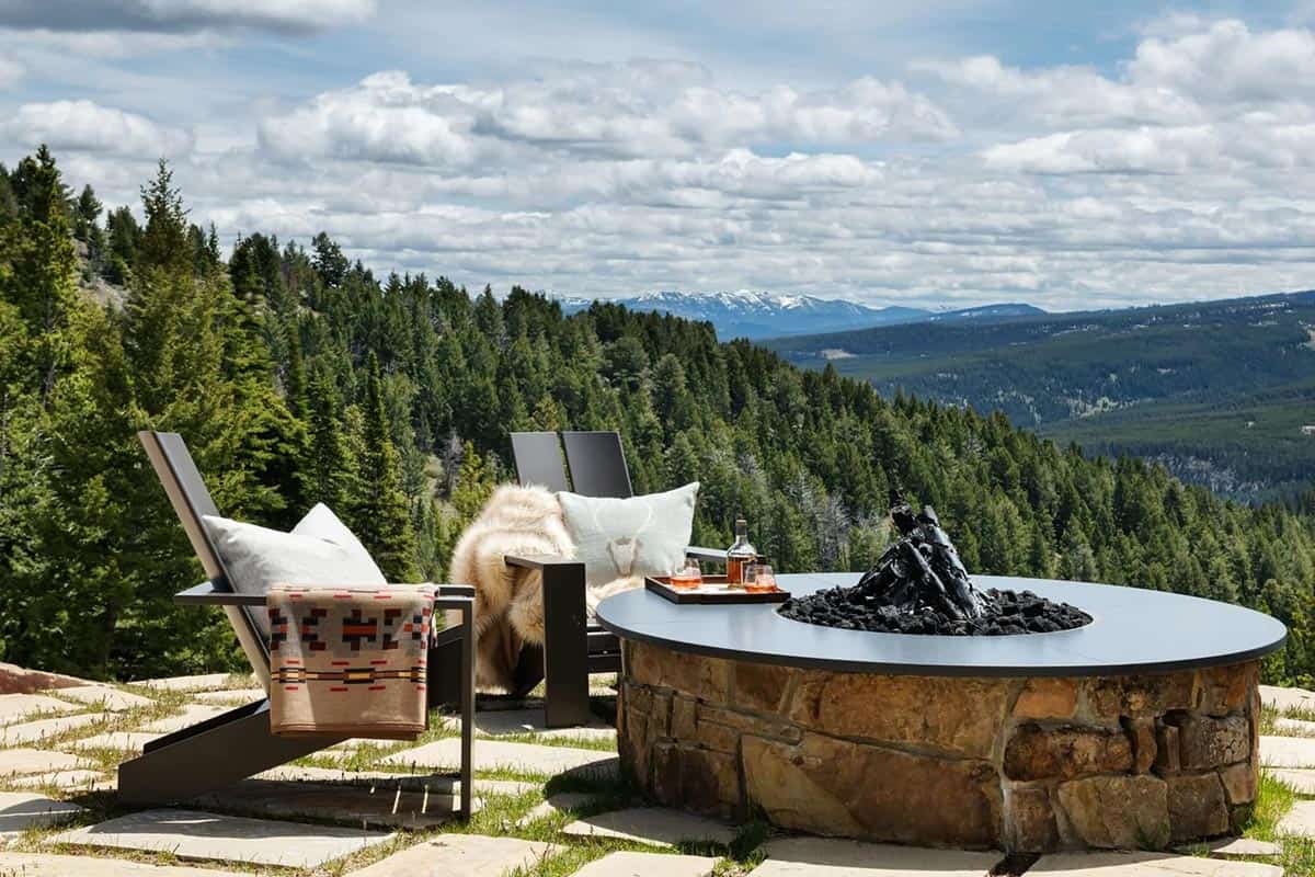 modern rustic mountain home patio with an outdoor fire pit