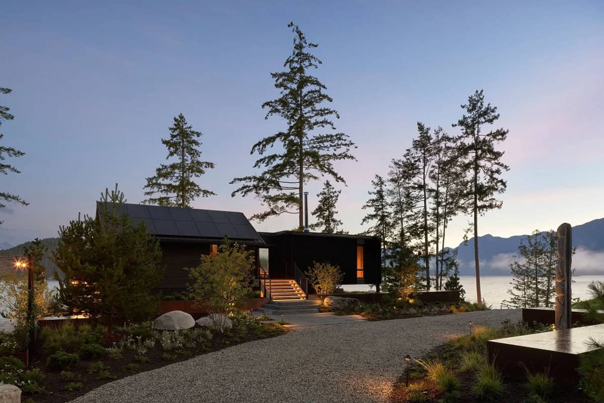 modern coastal home exterior with a driveway at dusk