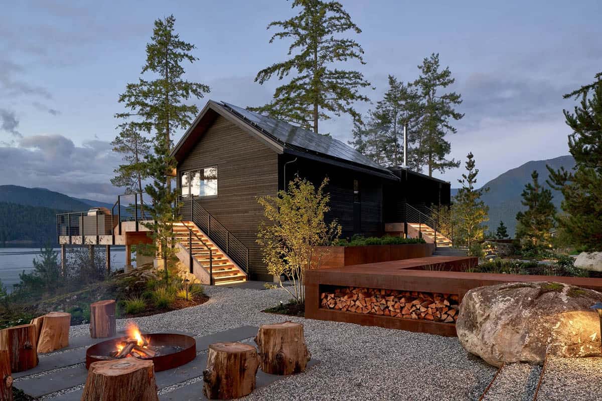 modern coastal home exterior with a backyard fire pit at dusk