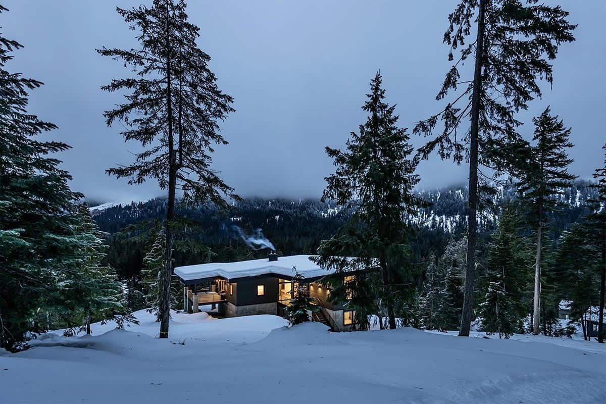 off-grid mountain cabin exterior with snow at dusk