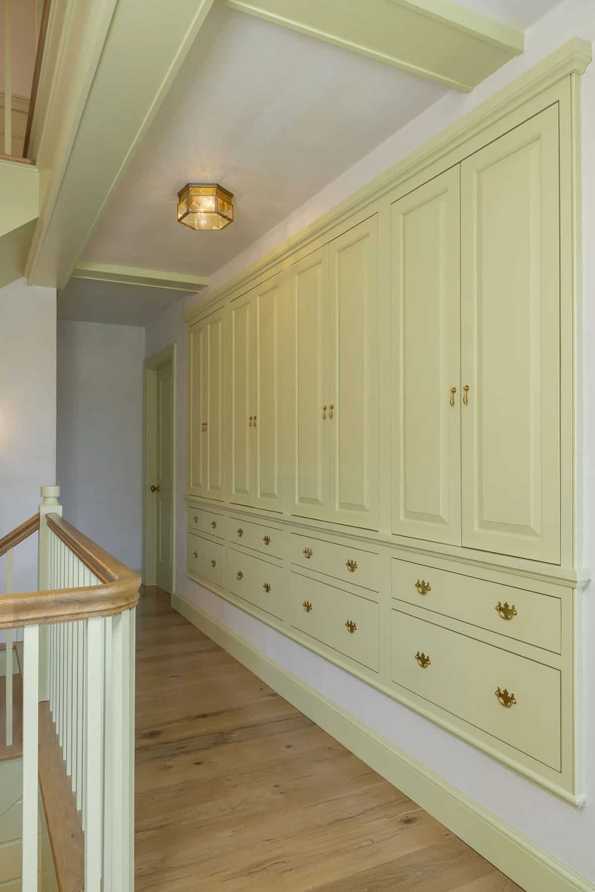 rustic staircase hallway with built-in storage wall