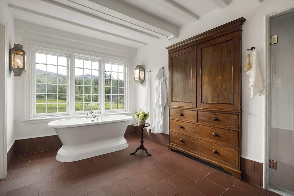 rustic bathroom with a soaking tub and large window