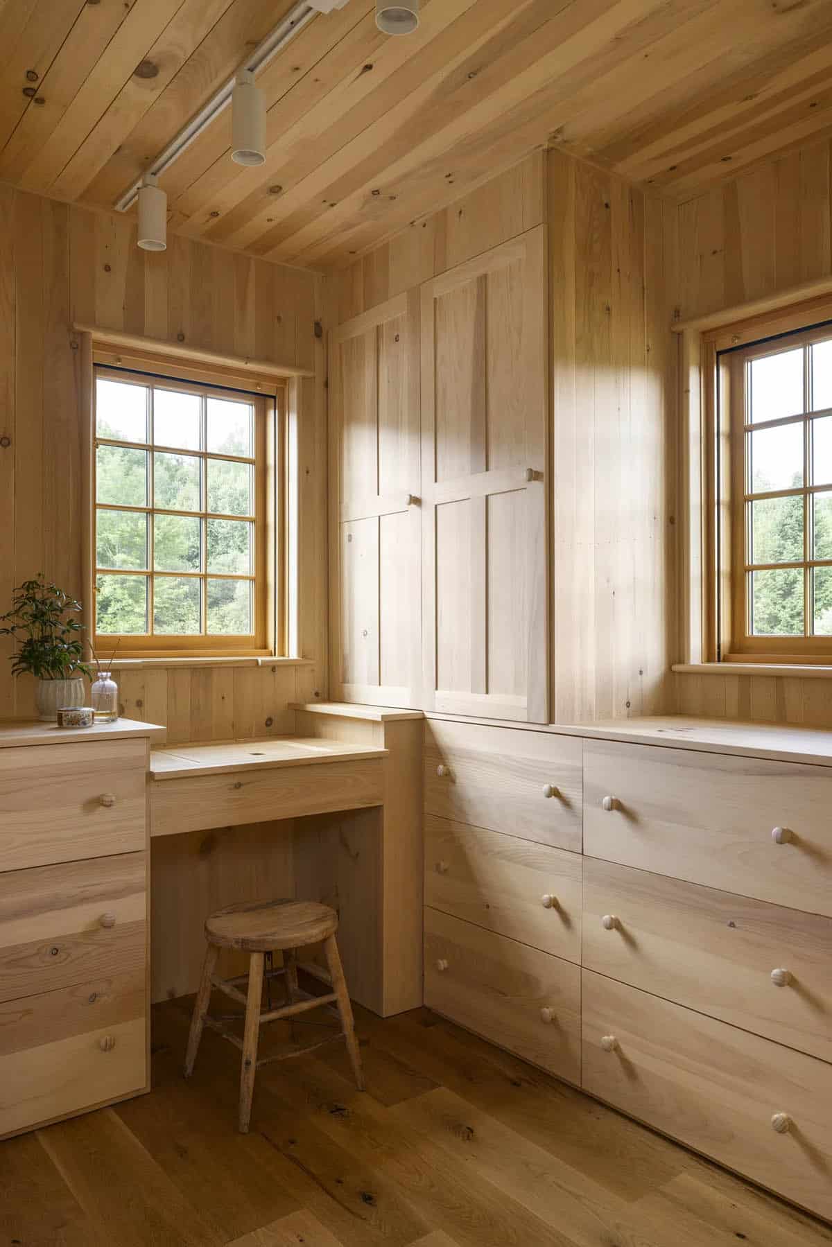 rustic walk-in closet with wall storage and a built-in makeup vanity with a window