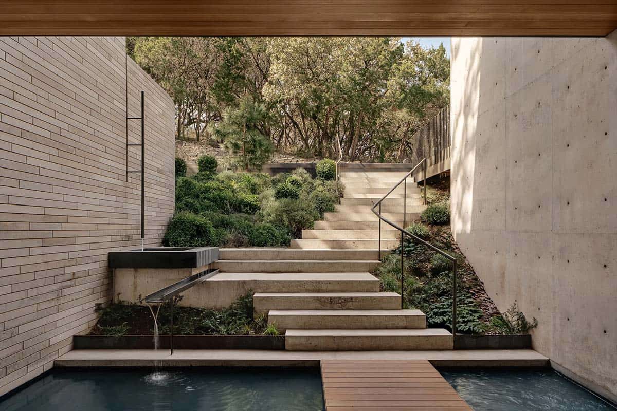 modern exterior with steps under a bridge and a water feature