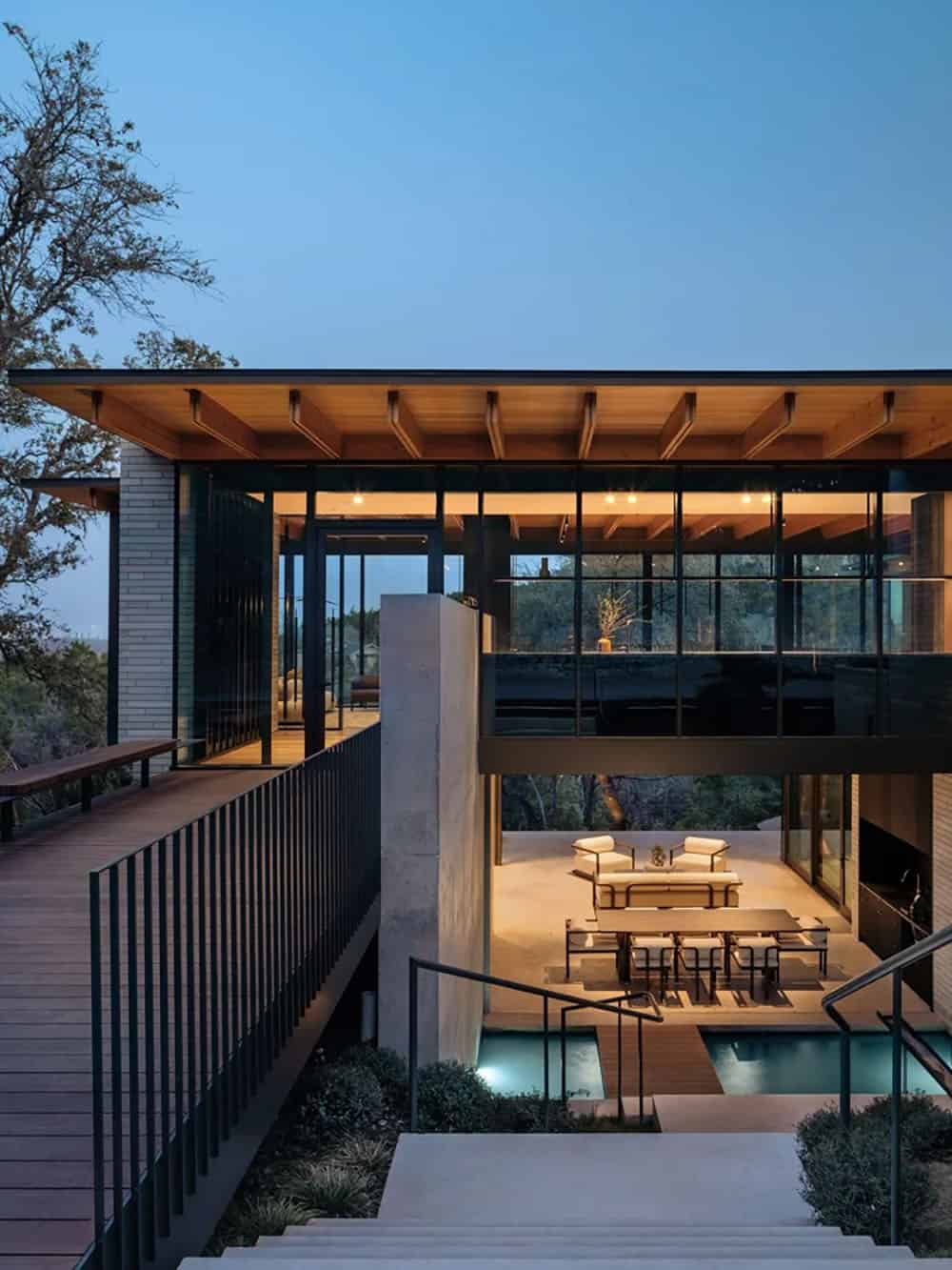 modern house exterior with a view of the pool at dusk