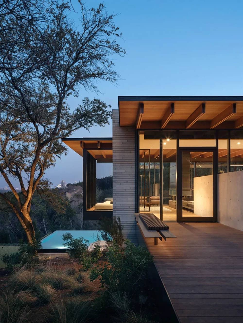 modern house exterior with a view of the pool at dusk