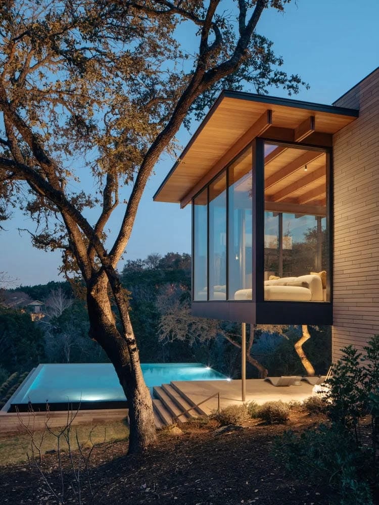 modern house exterior with a view of the pool at dusk