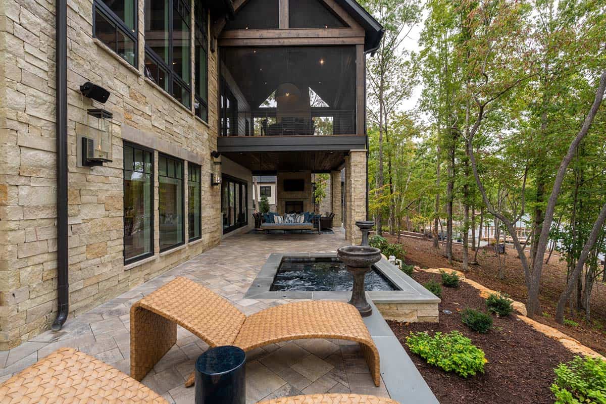 transitional style lake house exterior backyard view with a hot tub