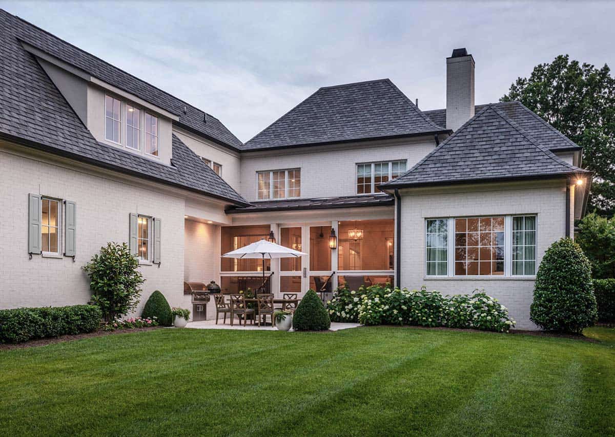 French Country home exterior backyard view with lush green lawn and mature landscaping, Belle Meade Nashville Tennessee