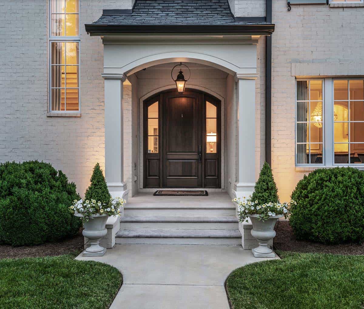 French Country home covered front entry with arched doorway and lantern lighting, Belle Meade Nashville