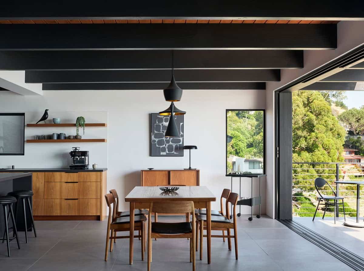 midcentury modern dining room with black painted beams teak cabinets Tom Dixon pendant lights and open to Bay views Klopf Architecture
