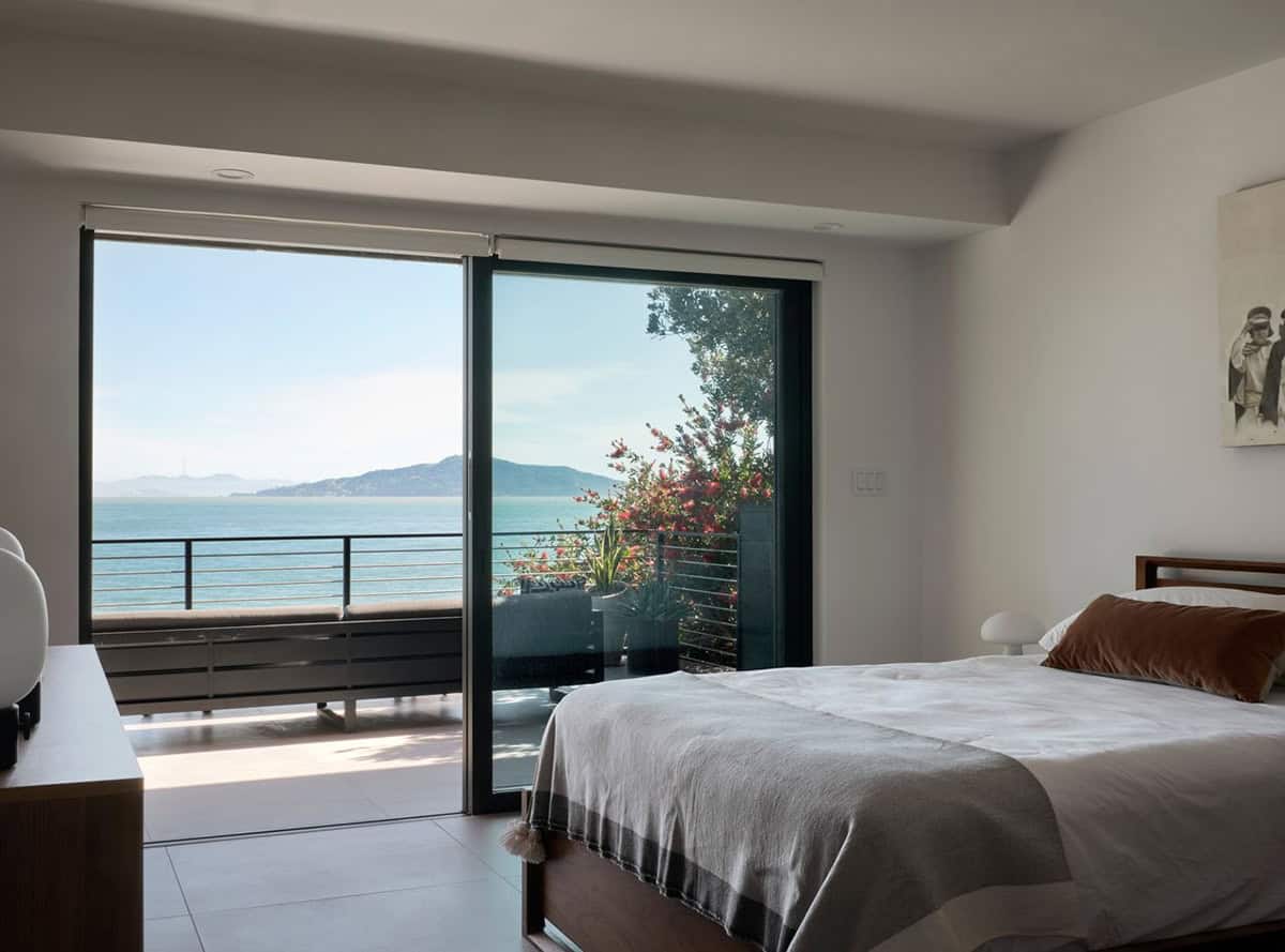 midcentury modern primary bedroom with sliding glass doors opening to San Francisco Bay view balcony Point Richmond California