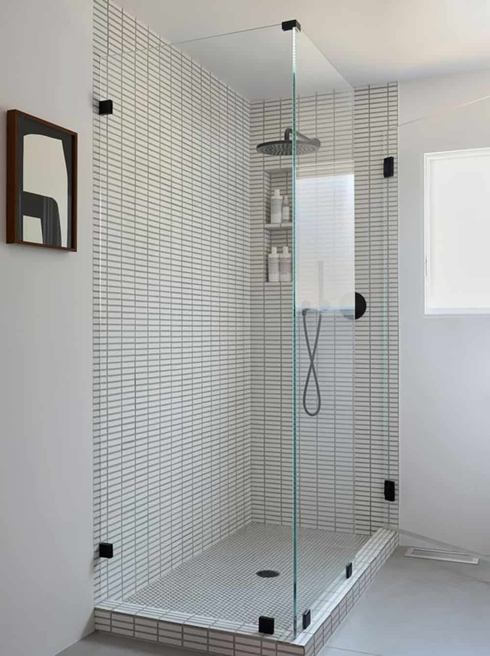 midcentury modern bathroom with frameless glass shower white stacked tile and matte black hardware Point Richmond California