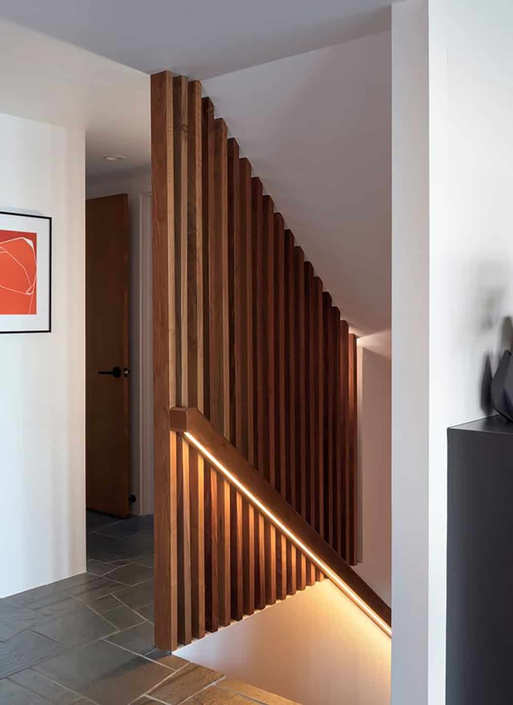 walnut slatted stair wall with LED under stair lighting and slate tile floor midcentury modern home renovation California