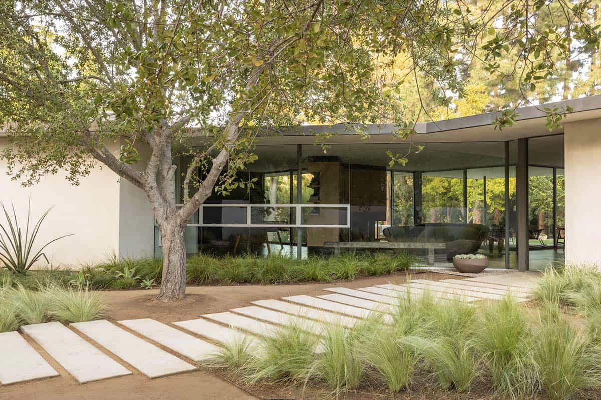 Mid-century modern home exterior with stepping stone path and ornamental grasses