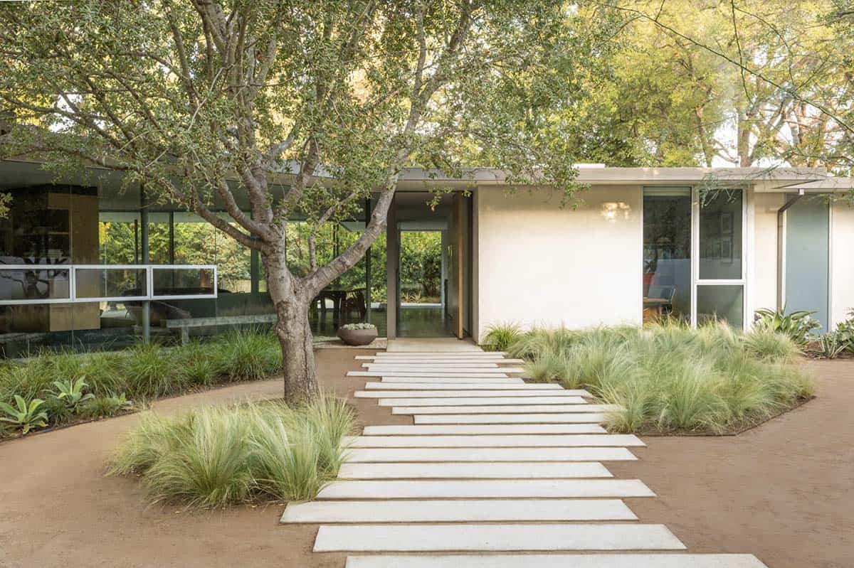 Concrete stepping stone walkway leading to mid-century modern home entrance