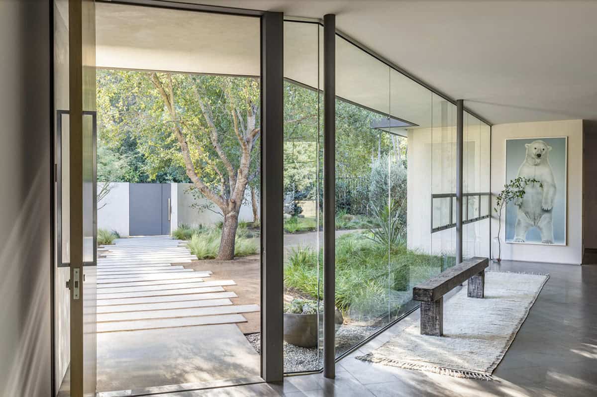 Glass wall interior entry hall with wooden bench and polar bear artwork