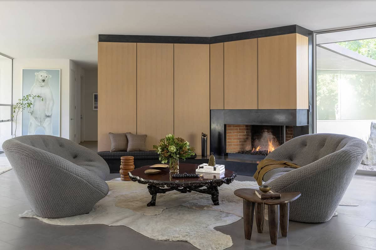 Symmetrical living room with paired gray tufted chairs flanking a fireplace