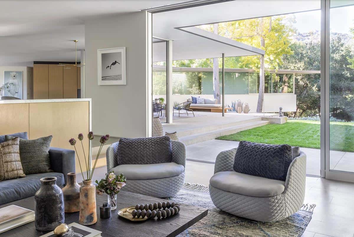 Family room with quilted armchairs opening to covered patio and lawn
