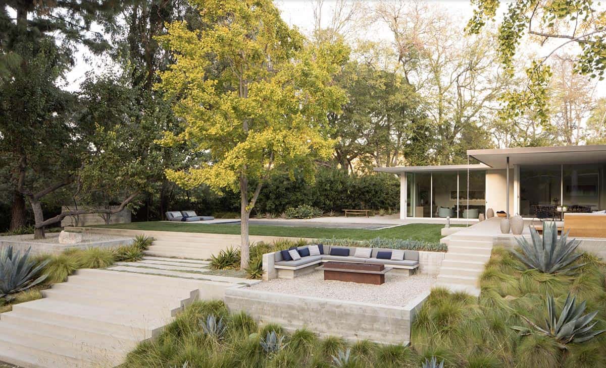 Terraced backyard with sunken fire pit seating area and mid-century modern home