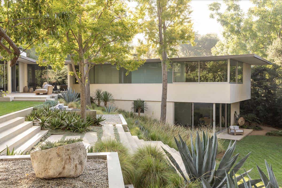 Two-story mid-century modern home exterior with agave garden and boulder landscaping