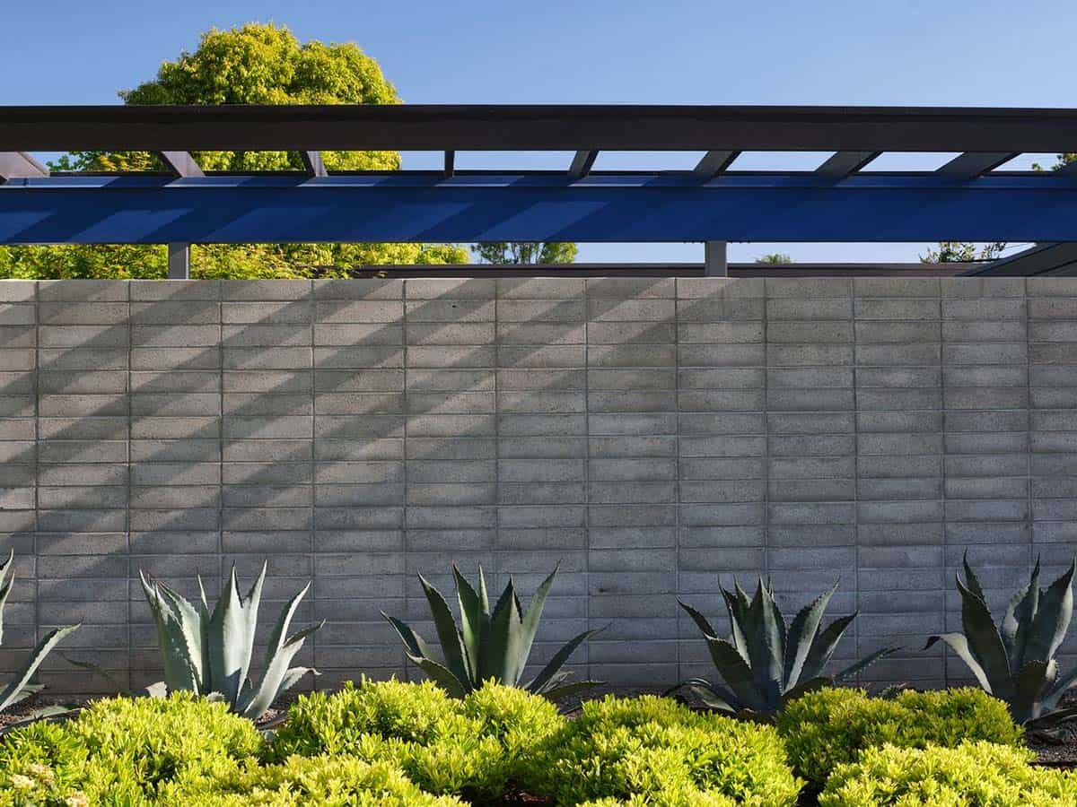 Eichler home front yard with concrete block wall blue steel pergola agave plants and low shrub landscaping