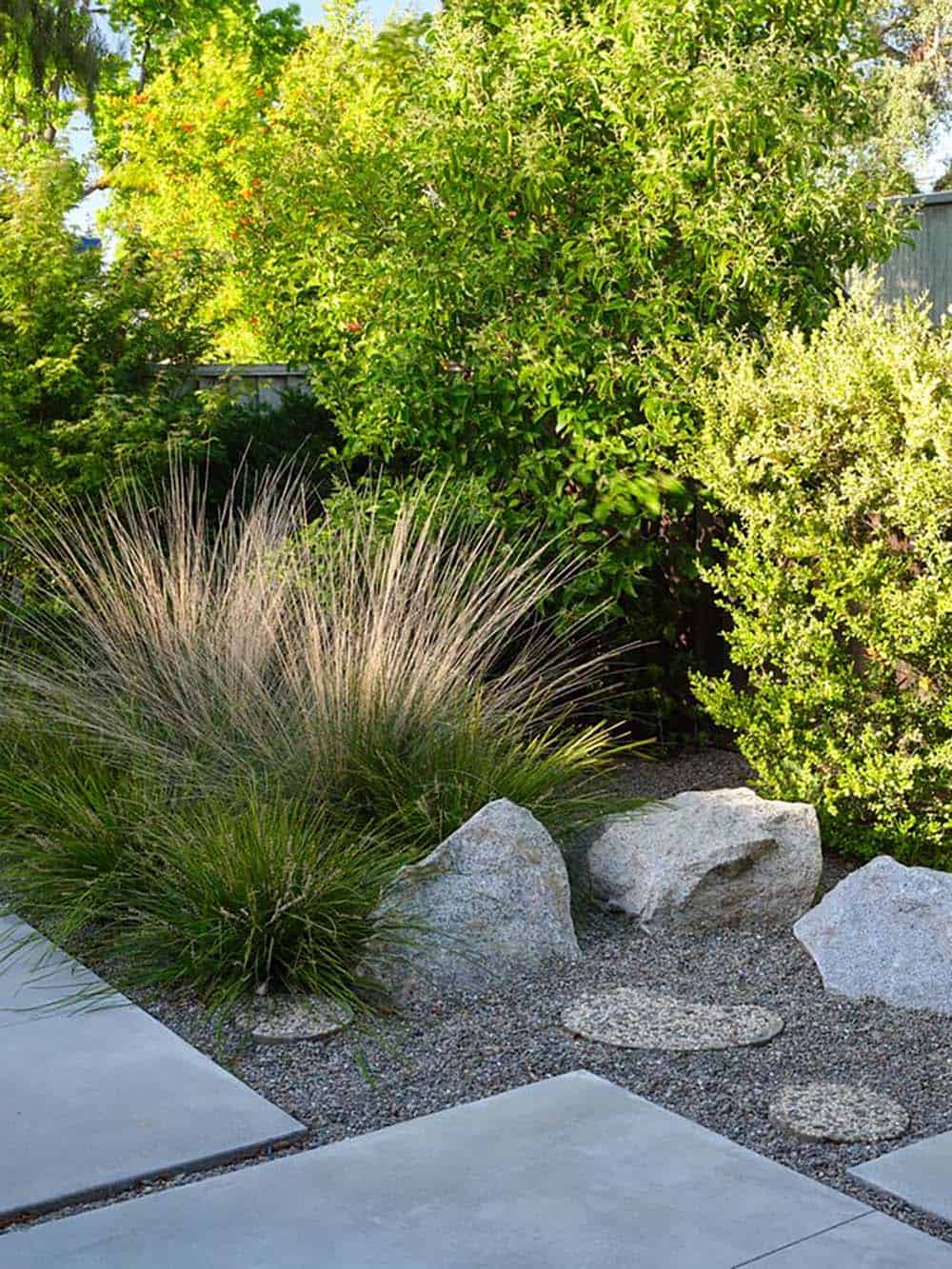 drought tolerant front garden with feather grass boulders gravel and concrete pavers mid-century modern Eichler home