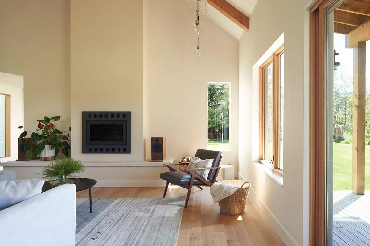 Living room seating area at the NorthShore Residence with generous windows overlooking the surrounding meadow and forest