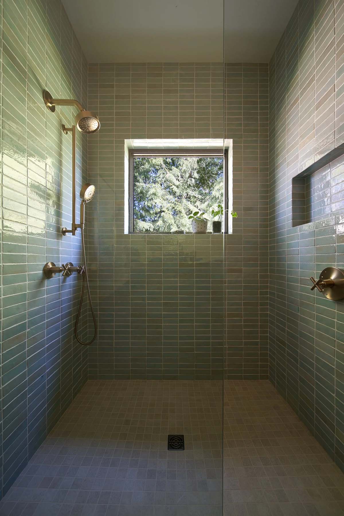 Walk-in shower in the NorthShore Residence primary bathroom with tile detailing and generous natural light