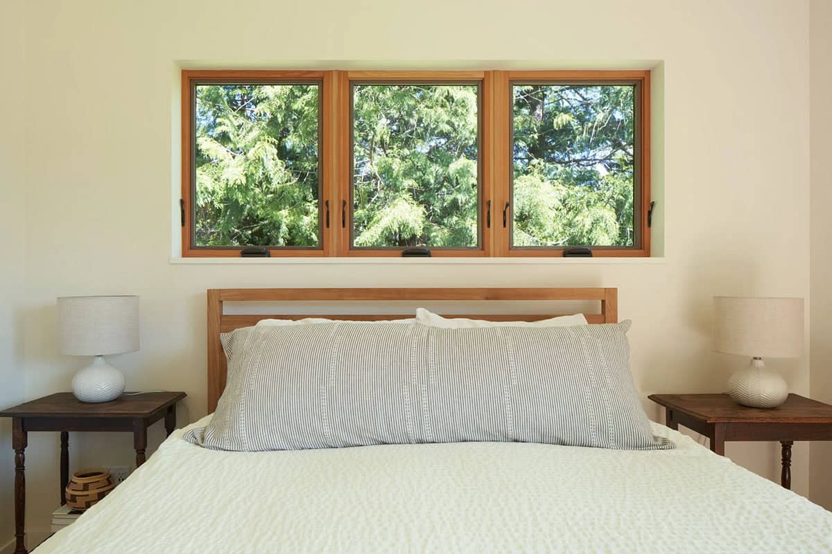 Primary bedroom at the NorthShore Residence with serene finishes, warm tones, and views of the Pacific Northwest landscape