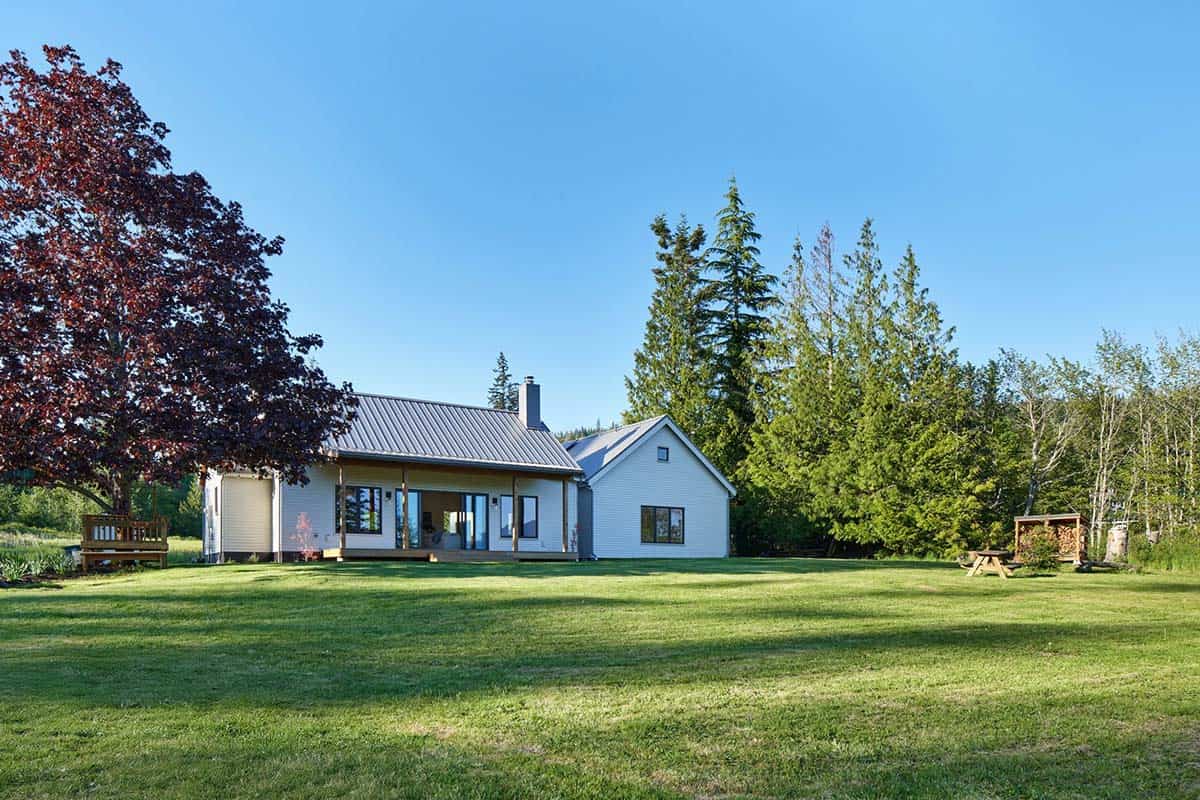 Wide exterior view of the full residence on its wooded Bellingham, Washington, lot showing single-level massing