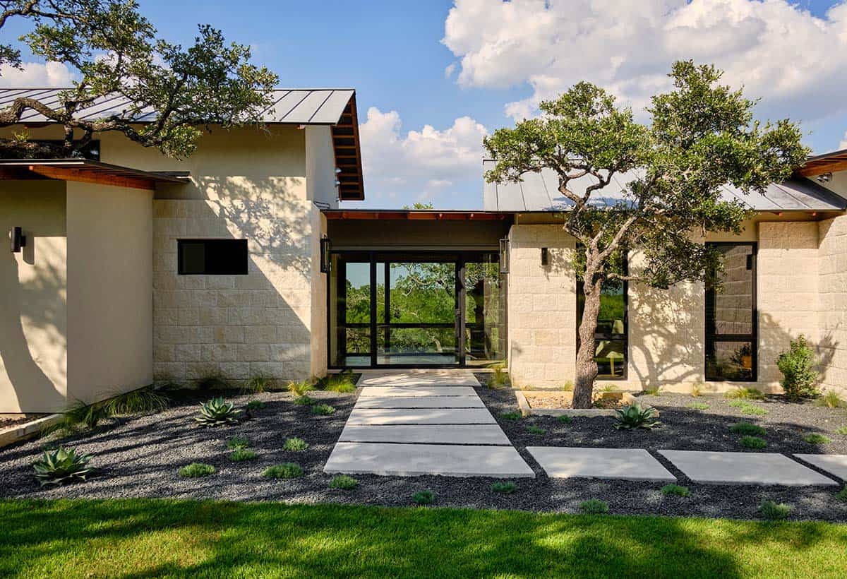 modern home with a stone exterior, a metal roof, and a landscaped front yard